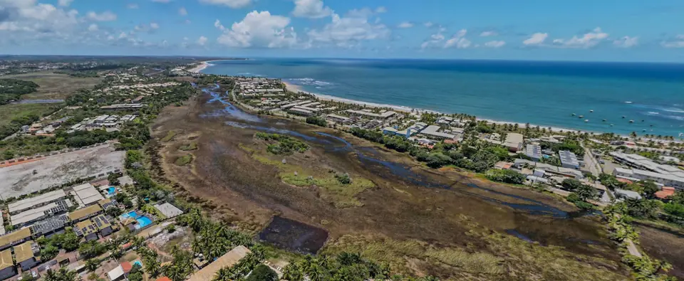 Vista aérea da orla de Itacimirim, com a praia, o mar e a lagoa ao lado da pousada