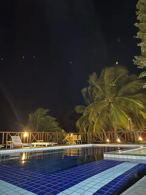 Piscina iluminada, ambiente romântico.