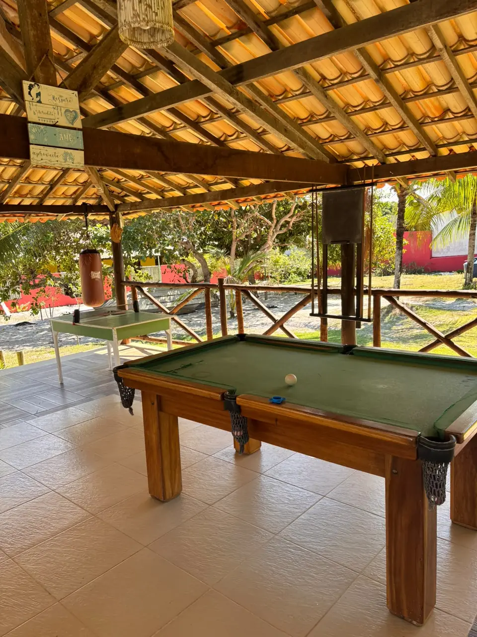 Sinuca em ambiente coberto, com vista para o jardim.
